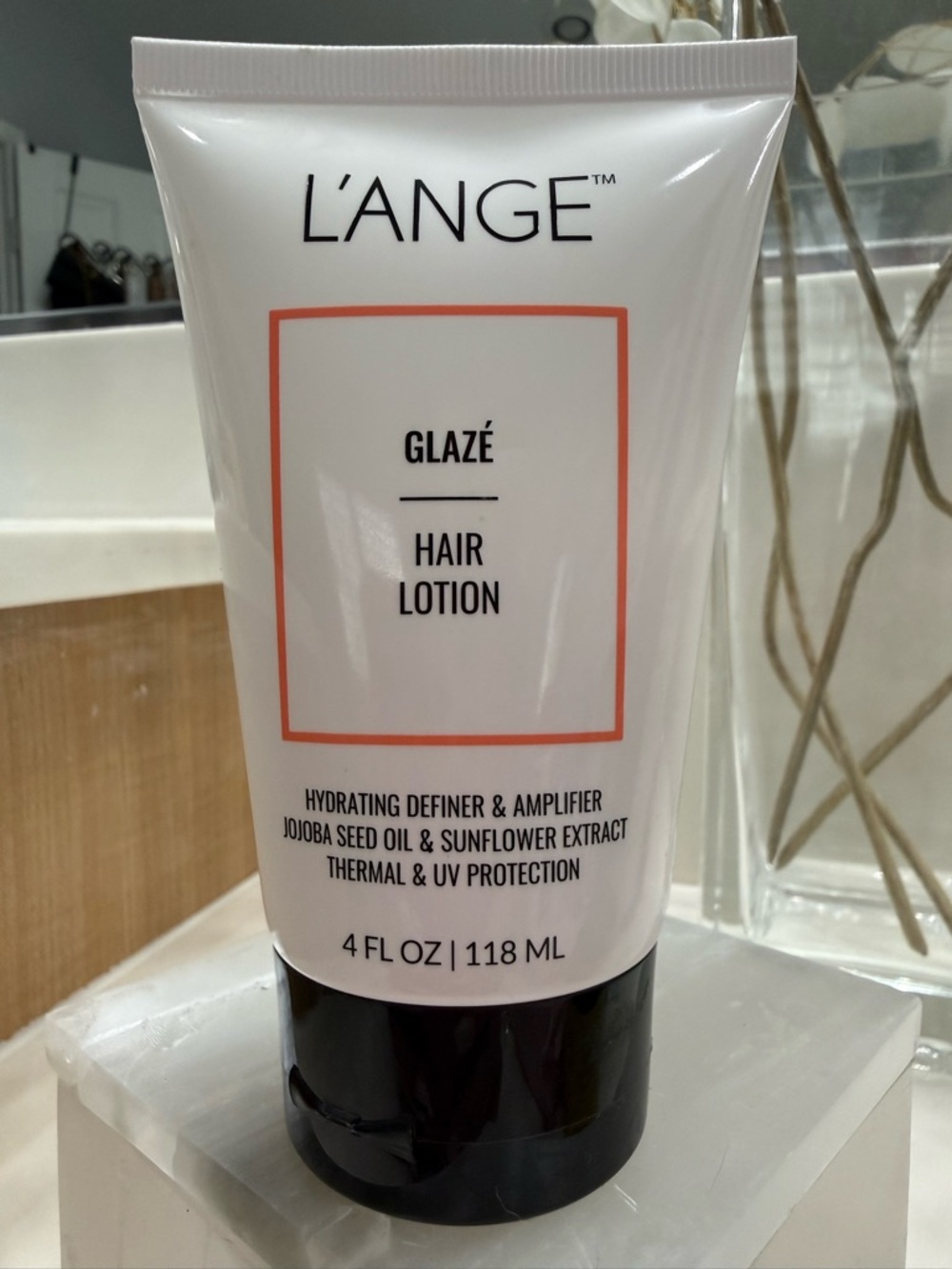 L'ANGE Glazé Hair Lotion - White Tube with Black Cap and Coral Accent